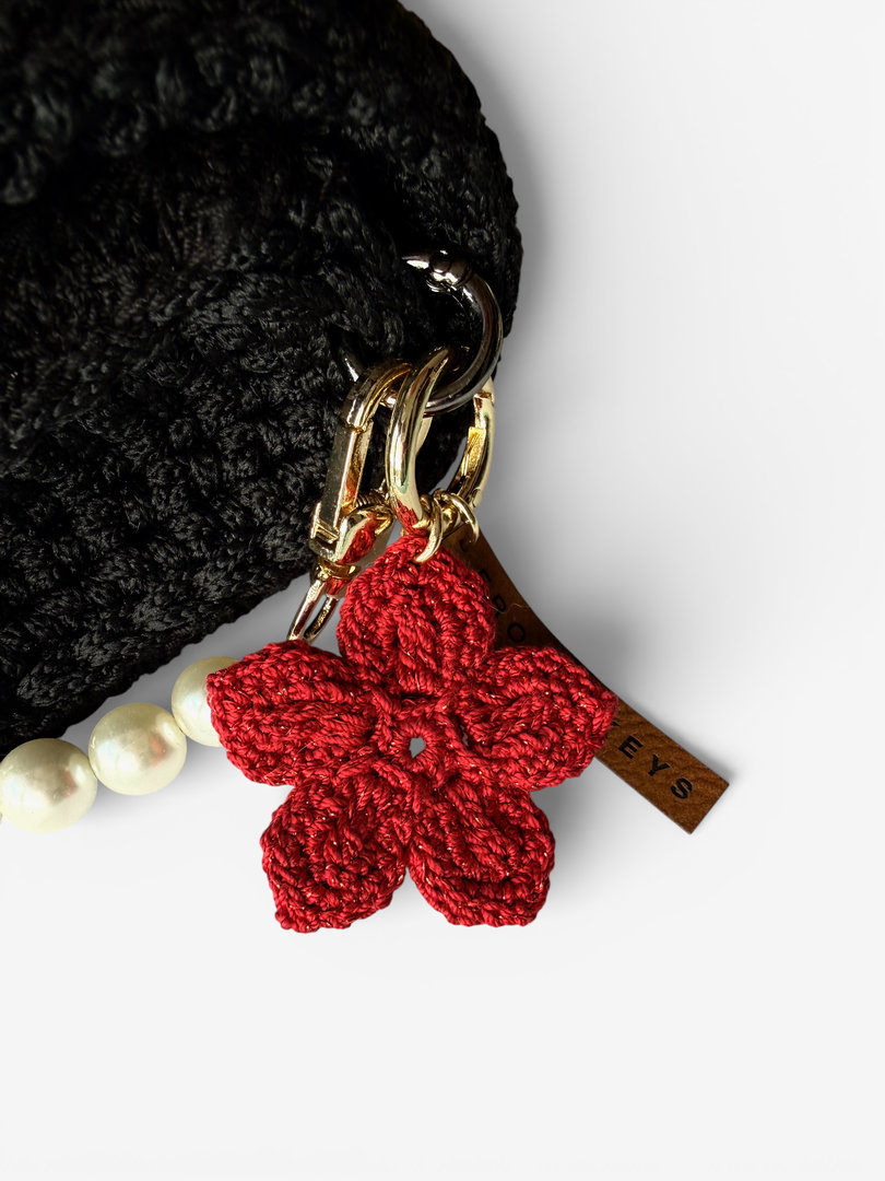 Brelok handmade czerwony z kwiatkiem i czerwoną nitką z bliska