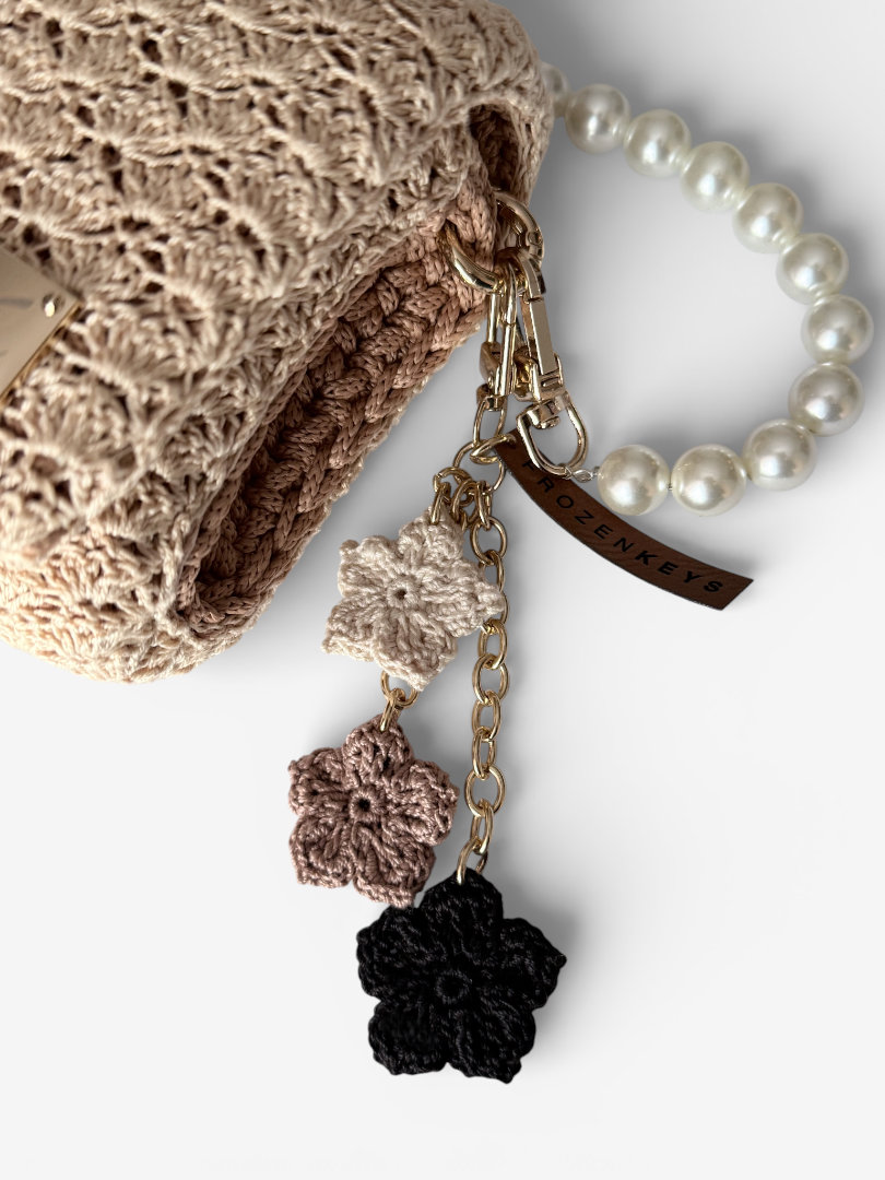 szydełkowy brelok z trzema kwiatkami beżowy ecru czarny przy torebce