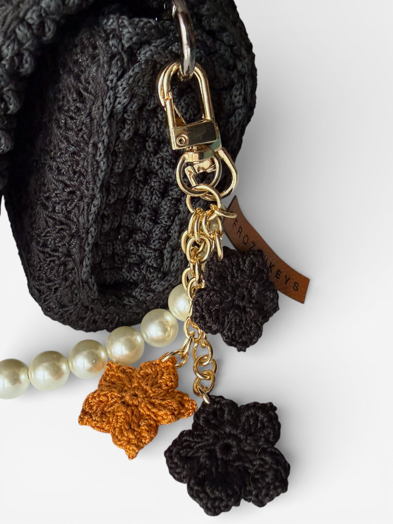 szydełkowy brelok z trzema kwiatkami musztardowy czarny przy torebce