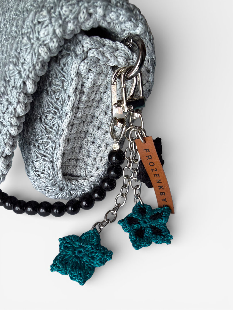 szydełkowy brelok z trzema kwiatkami turkusowy czarny przy torebce